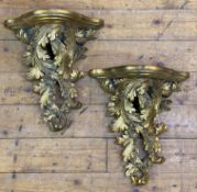 A pair of modern Rococo-style gilt wall brackets, shelf to top over scrolling foliate decoration: H.