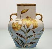 A late 19thc twin handled ceramic vase, with textured body, and hand-painted yellow lilies,