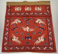 A Chinese late 19thc hanging textile / door pelmet on red textile ground, with various silk threaded