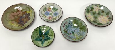 A collection of five Chelsea Pottery footed dishes of varying sizes, each with polychrome foliate