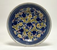 A 19thc European tin-glazed earthenware sharing plate, decorated with foliate motifs to centre and