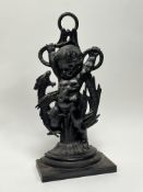 A cast iron doorstop in the form of a cherub wrestling a serpent (h. 46cm)