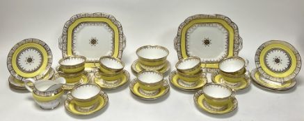 A Collingwood tea service decorated with gilt scrolls and star design with yellow border, comprising
