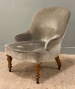 A Victorian nursing chair, arched top and button-back, upholstered in soft green velvet, raised on