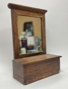 An oak-framed bathroom wall-hanging mirror with rectangular cabinet, hanging hooks verso (h. 47cm