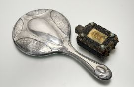 A early 20thc white metal dressing table hand mirror with flower head embossed panels in the Art