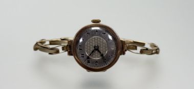 A vintage 9ct gold watch with silvered dial and arabic numerals on expanding 9ct gold bracelet: d. x