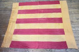 A Durham quilt in burnt umber and raspberry panelled design (223cm x 188cm)