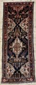 A hand-knotted Persian Hamedan runner, central field with geometric flowerhead and vine motifs