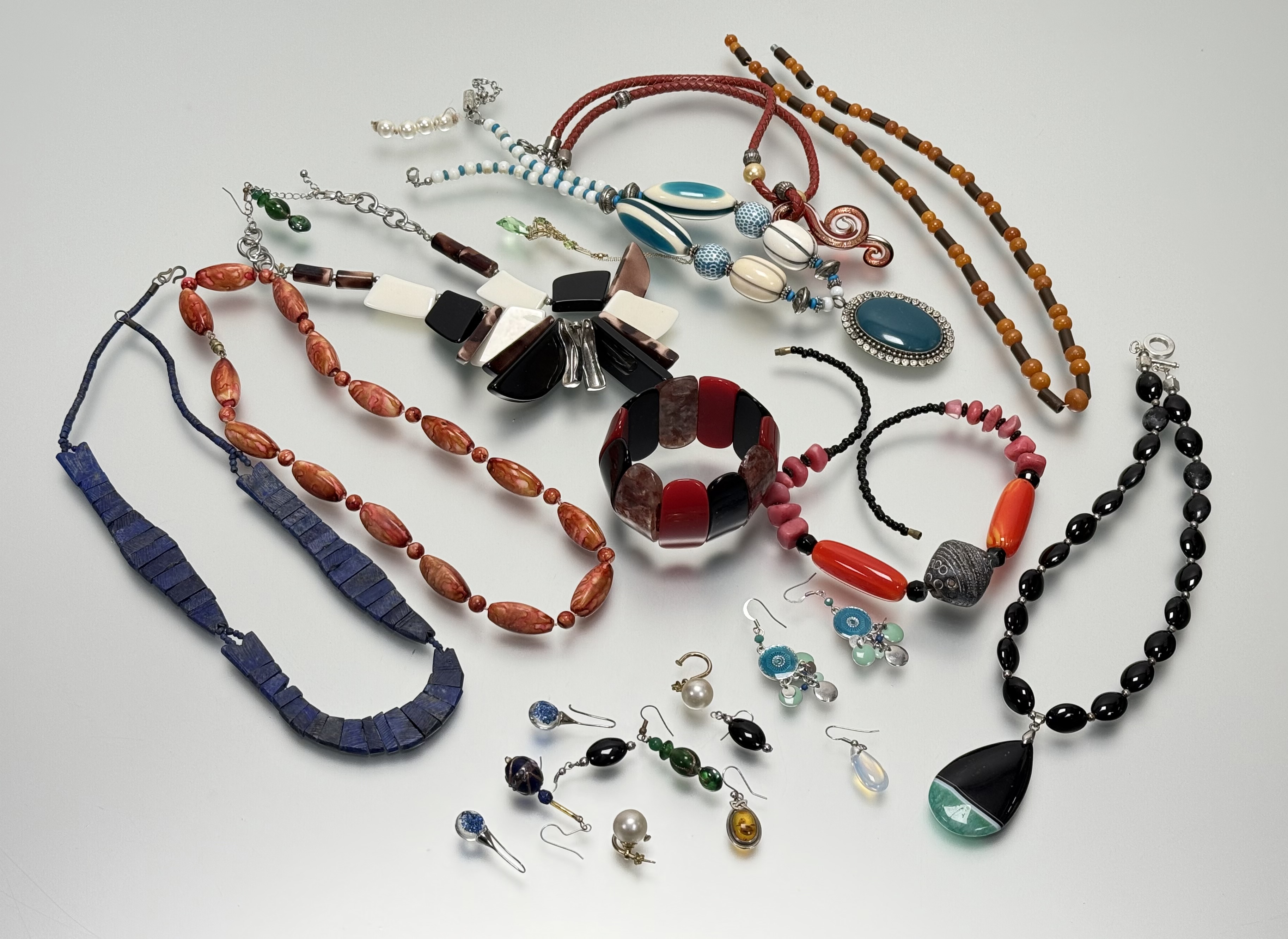 A collection of fashion costume jewellery to include bead necklaces, paste pearls, ceramic panel