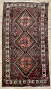 A hand-knotted Persian Hamedan rug, central panel with three medallions enclosed within a border