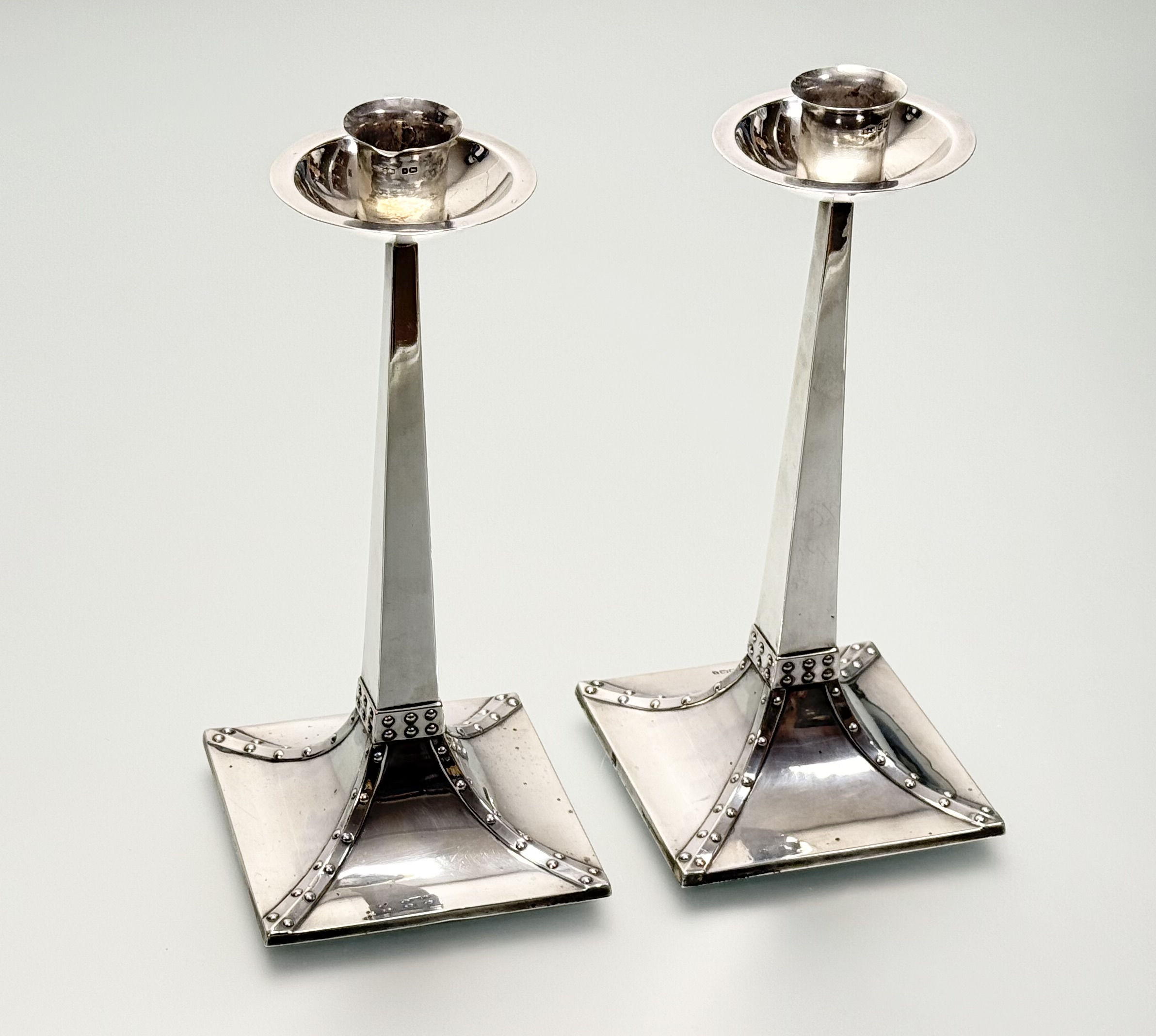A pair of Edwardian silver candlesticks in the Arts & Crafts taste, James Dixon & Sons, Sheffield
