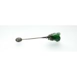 An Art Deco diamond and onyx mounted carved jade jabot pin, the jade modelled as a bud set with