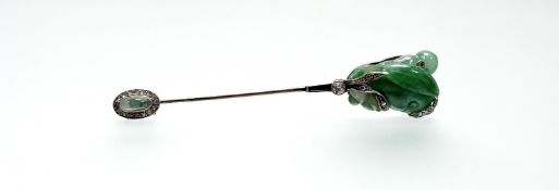 An Art Deco diamond and onyx mounted carved jade jabot pin, the jade modelled as a bud set with