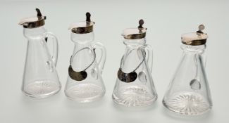 An assembled set of four silver-mounted cut-glass toddy jugs, two Hukin & Heath, Birmingham 1931,