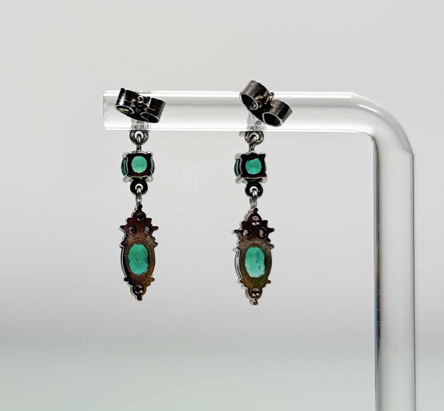 A pair of 9ct white gold pendent earrings each set with an oval emerald (enhanced) of - Image 2 of 2