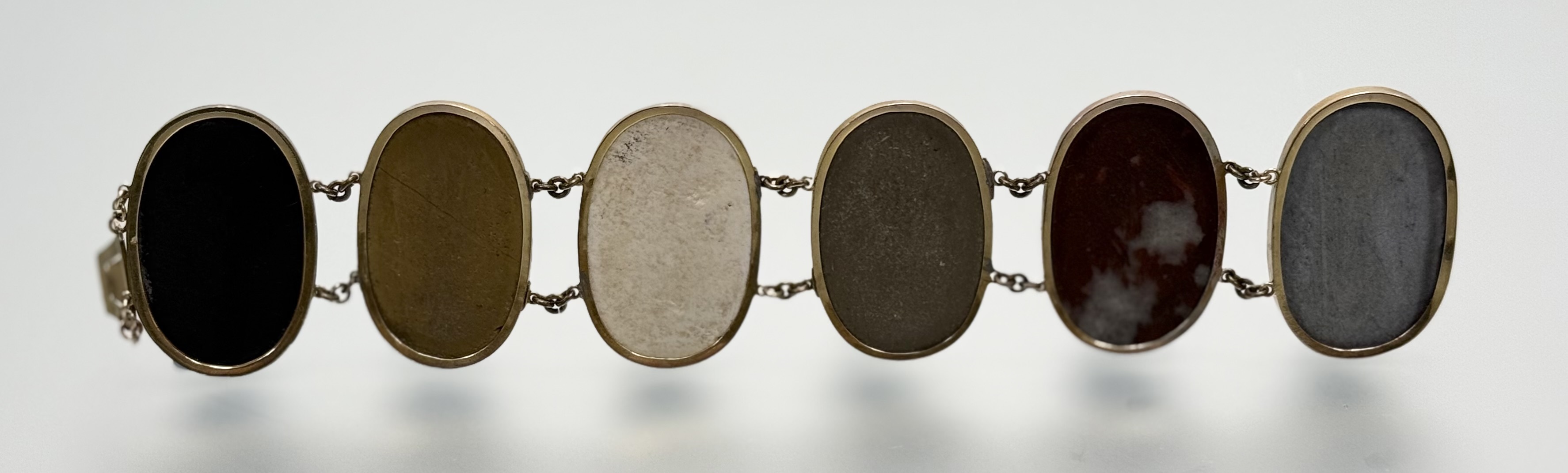 A 19th century lava cameo bracelet, formed of six oval cameos carved with Classical Muses, mounted - Image 2 of 3