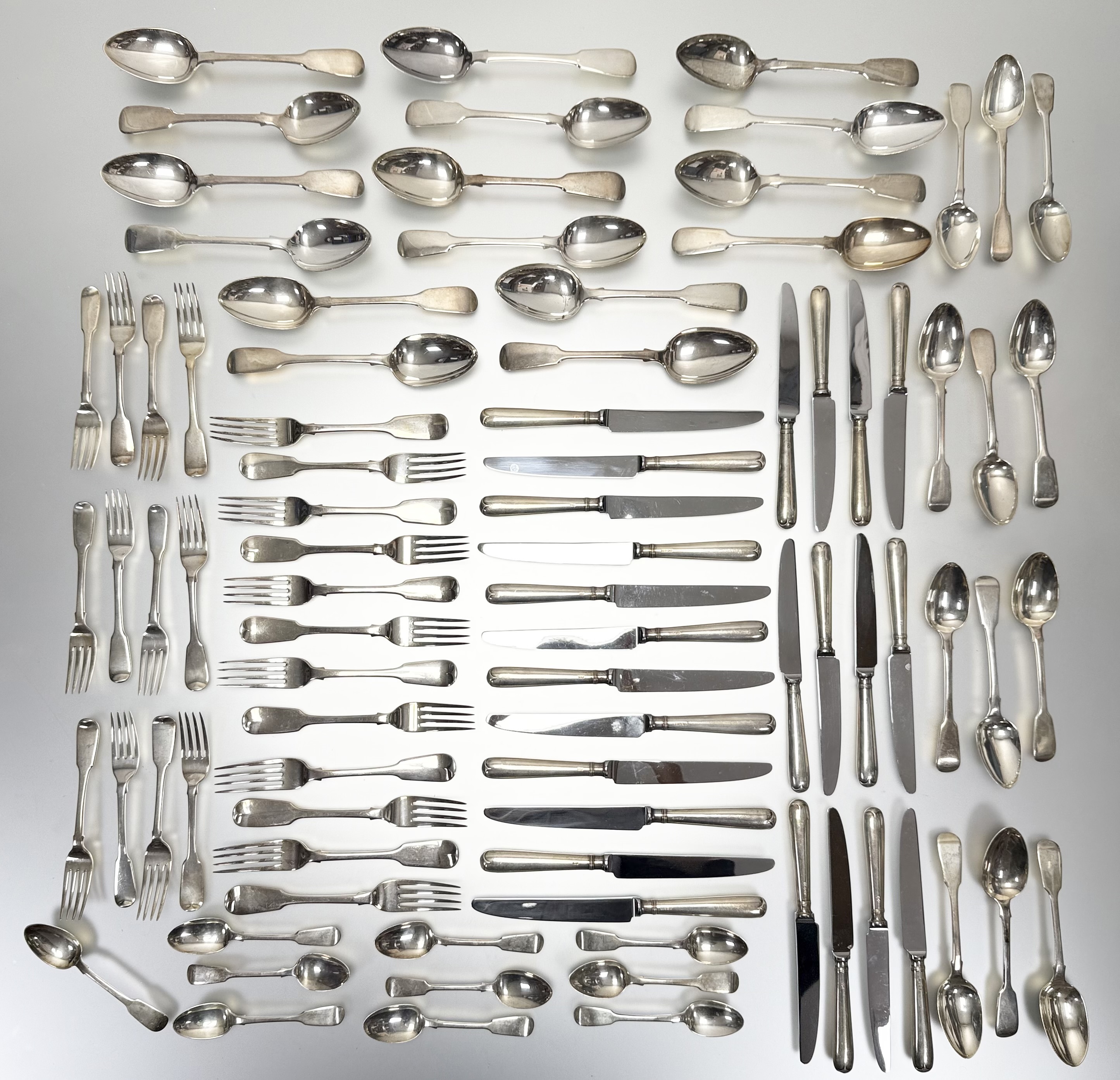 A George III style crossbanded walnut canteen table containing a composed silver flatware service,