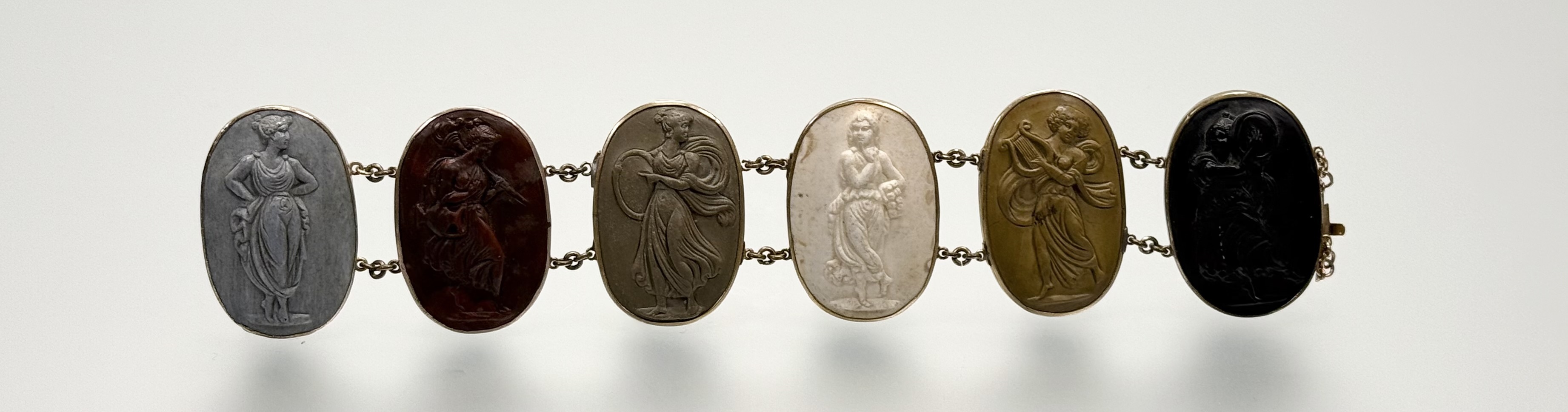 A 19th century lava cameo bracelet, formed of six oval cameos carved with Classical Muses, mounted