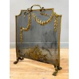 An Edwardian brass firescreen, the mesh screen applied with foliate and floral swags and raised on