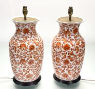 A pair of Chinese iron red painted porcelain vasiform table lamps, modern, each on an ebonised
