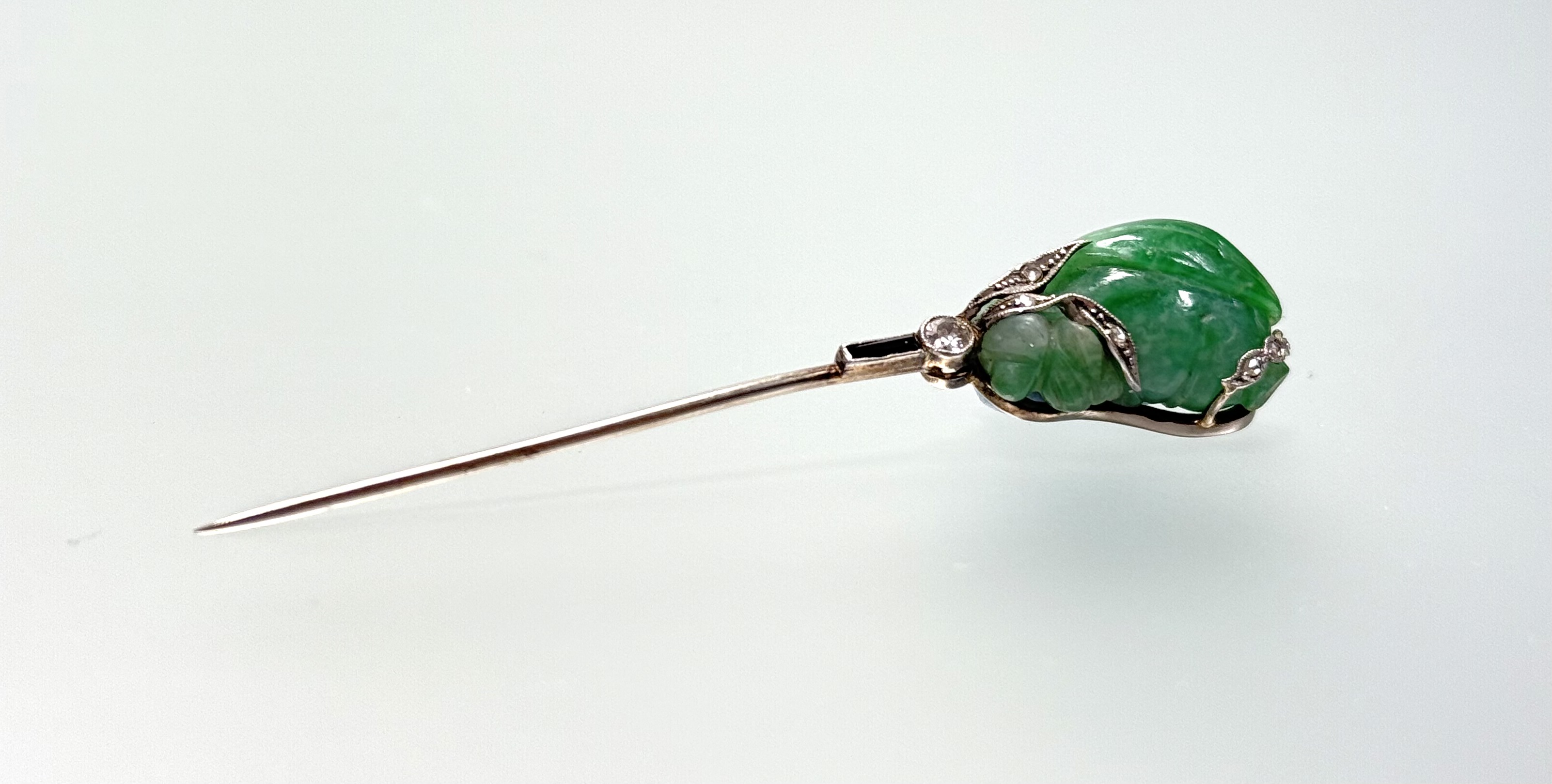 An Art Deco diamond and onyx mounted carved jade jabot pin, the jade modelled as a bud set with - Image 2 of 2