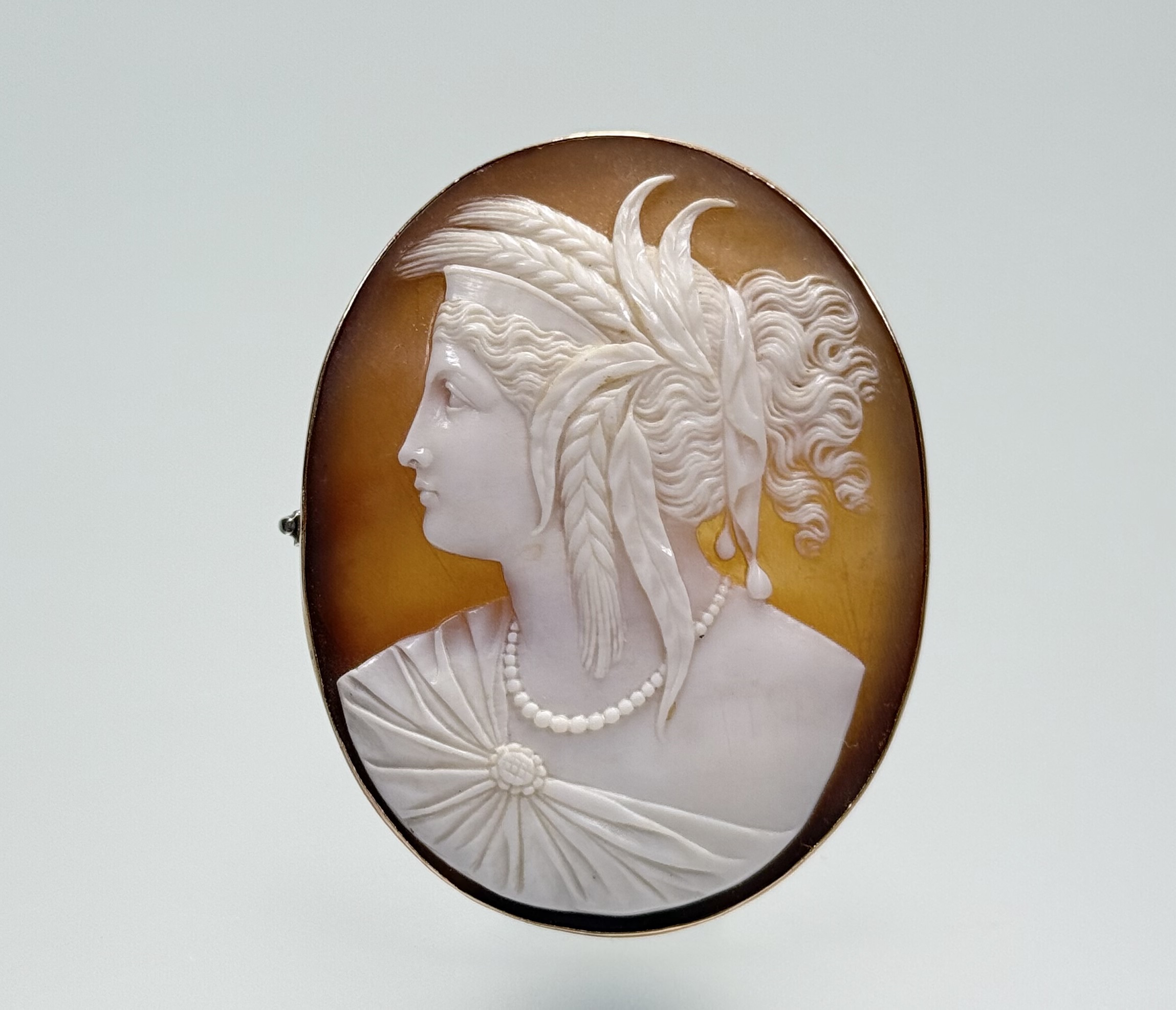 A late 19th century gold-mounted shell cameo brooch, the cameo carved with a profile bust of the