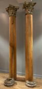 A pair of pitch pine, tapered pillars with Corinthian Capitals, 19th century, the capitals of carved