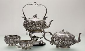 A substantial Burmese white metal four piece tea service, c. 1900, comprising a kettle and burner on