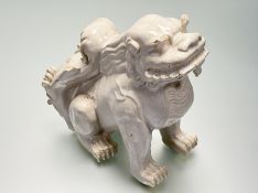 A Chinese white-glazed pottery model of a lion dog, probably 20th century. Height 26cm.