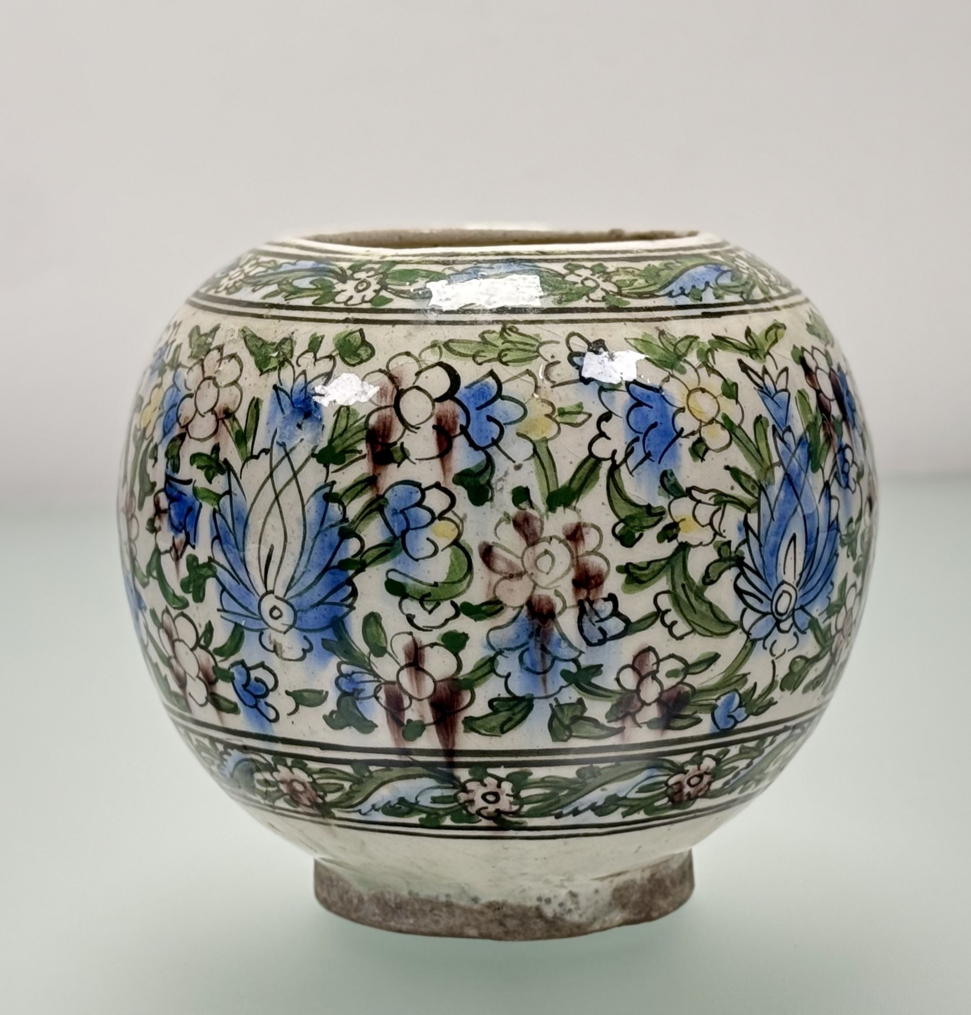 A Persian Qajar style pottery vase, probably early 20th century, painted with flowers and foliage. - Image 2 of 5