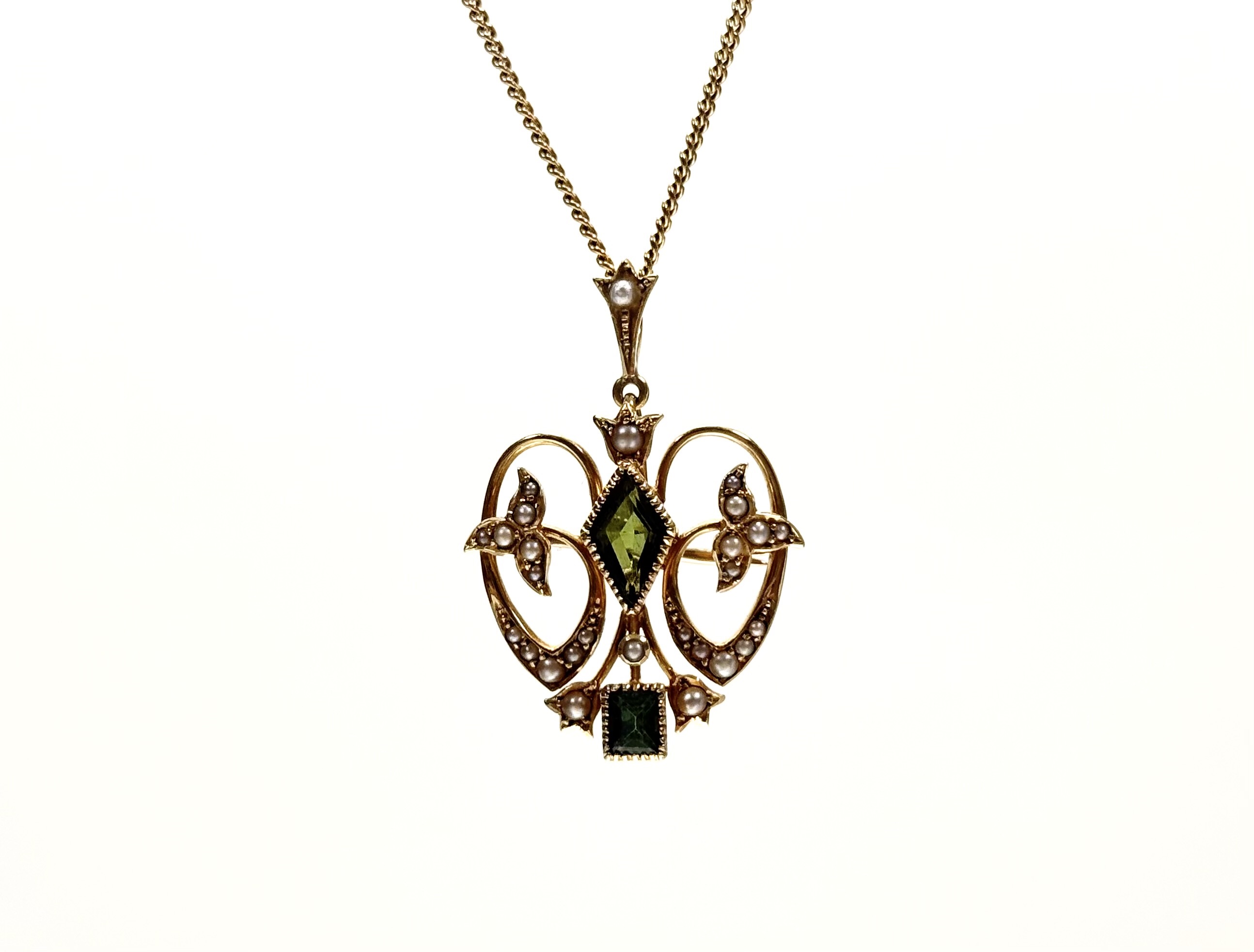 An Edwardian 15ct gold, green tourmaline and seed pearl pendant with brooch fitting, of open