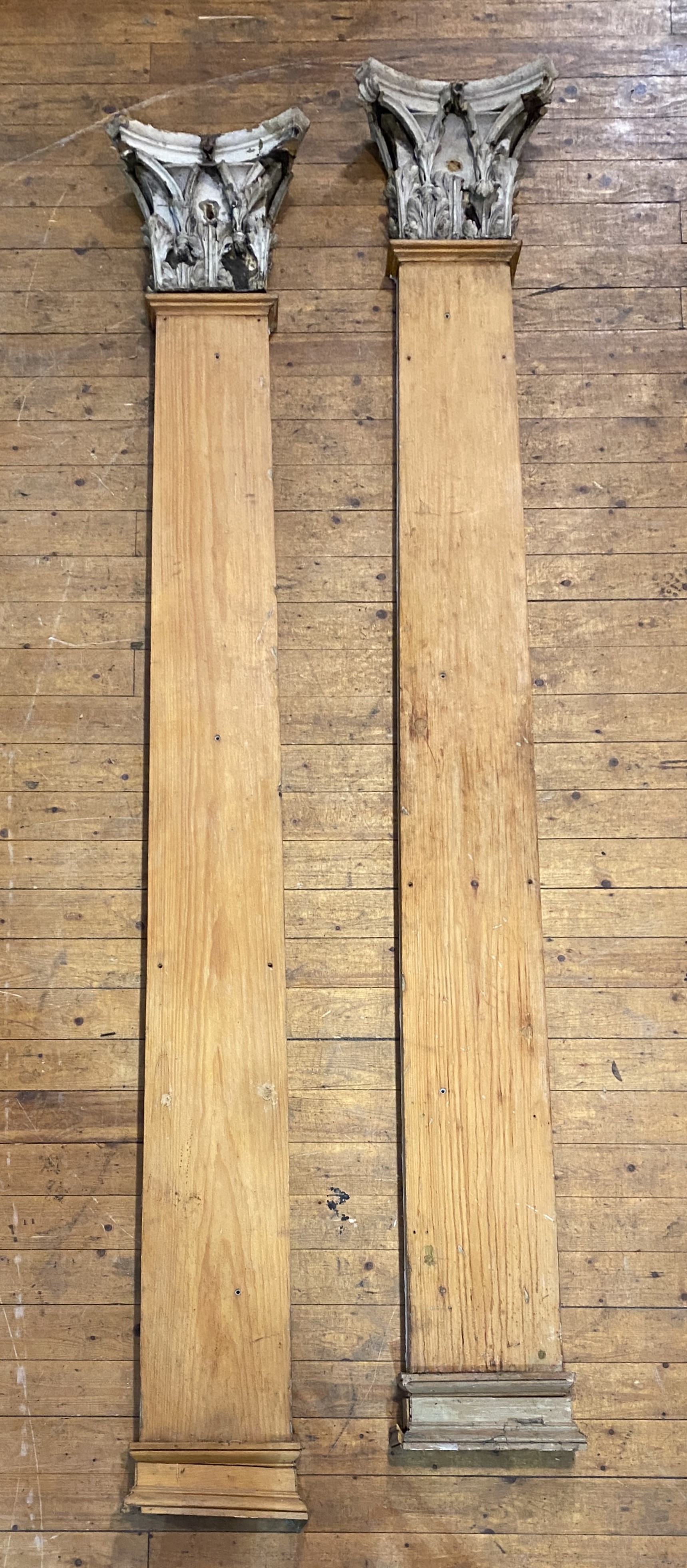 A pair of pitch pine pilasters with Corinthian capitals, tapering, the capitals of carved wood and