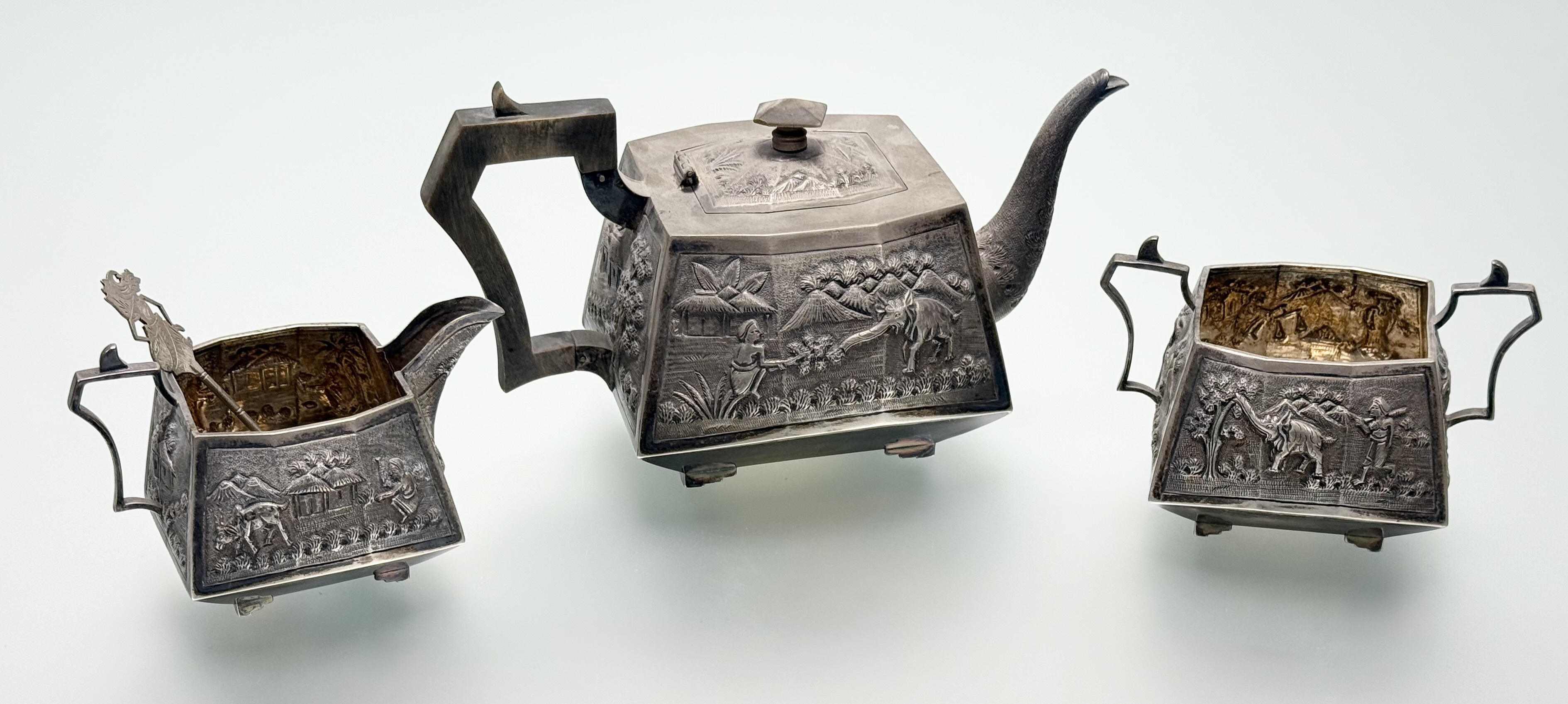 A sterling silver three piece tea service, probably Indian, c. 1900, each piece repousse with