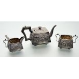 A sterling silver three piece tea service, probably Indian, c. 1900, each piece repousse with