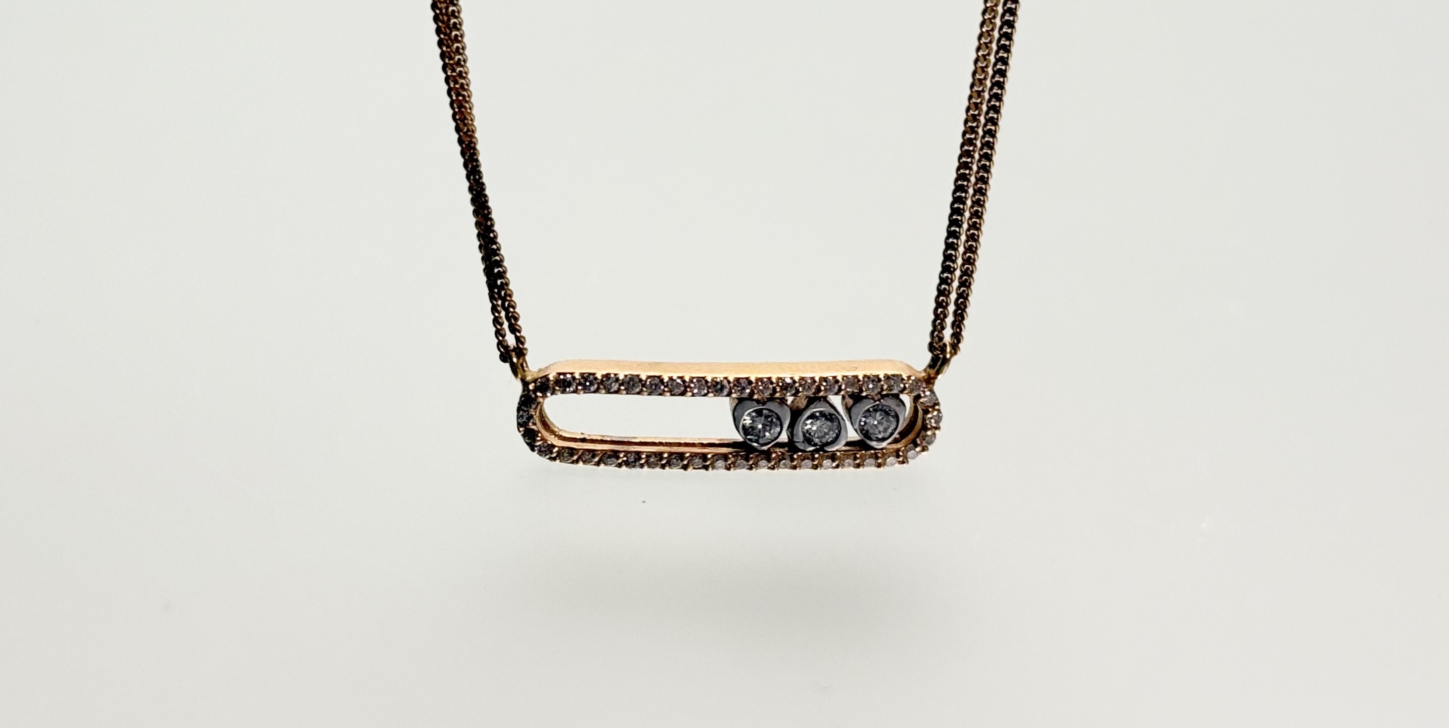 An 18ct rose gold and diamond "Move" necklace in the style of Messika, Paris, the central oval
