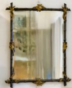 A painted and giltwood wall mirror, the frame carved as bamboo shoots and leaves, 20th century.
