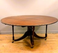 An early 19thc mahogany oval dining table the inlaid border with ivory stringing to the edge, on