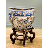 A modern large Japanese porcelain goldfish bowl raised on stained hardwood stand, decorated with