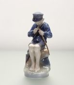A Royal Copenhagen figure of a seated boy trimming a stick, model number 905, marked verso. (h-