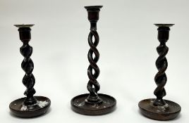 A pair of Victorian oak barley twist candlesticks with brass drip trays (h. 26cm), together with a