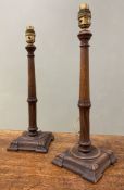 A pair of early 20th century oak table lamps, turned central column with leaf detail on square bases
