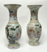 A pair of Chinese vases in the famille rose style, painted with panelled figures in palatial scenes,