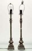 A pair of 20thc rococo style table lamps, in a silver and dark gold painted base and top, raised