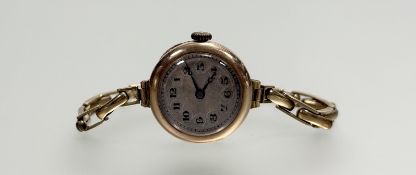 A vintage 9ct gold manual wind wristwatch with silvered dial and arabic numerals: d. x 2cm on 9ct