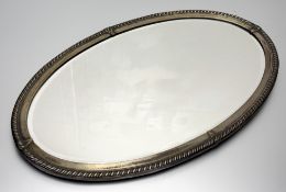 An oval hall mirror with a moulded twisted silver metal frame with bevelled glass mirror panel. (