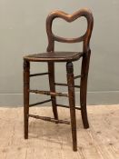 An early 20th century elm cello stool, balloon back and pierced seat, raised on turned tapered