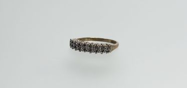 A 9ct gold ring set two rows of nine diamond points in a white metal setting L 1.92g