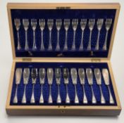 An Edwardian walnut canteen containing a set of twelve pairs of epns engraved fish knives: l. x 19cm