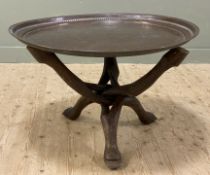 A late 19th/ early 20th century brass tray and stand, tooled tray top with foliate motifs raised